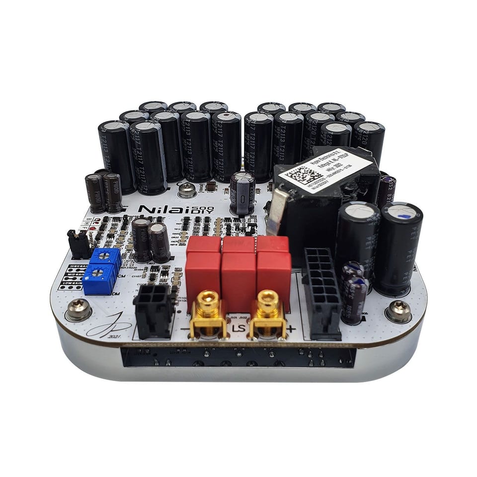 A bare Hypex Nilai500 DIY amplifier module: a white circuit board carrying two arcs of electrolytic capacitors, three red output relays, gold-plated speaker terminals marked LS, gain-setting jumpers labelled high, mid and low, and a machined aluminium heatsink base.
