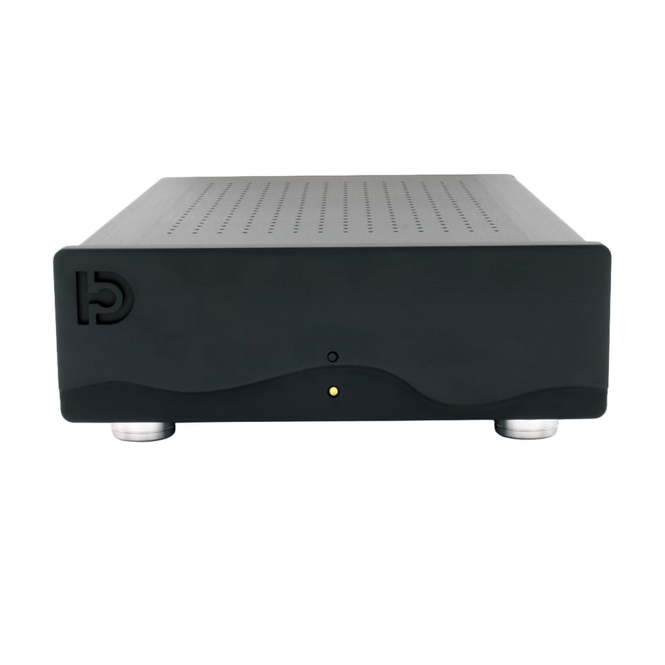 A finished Nilai500 mono kit: a compact black anodised aluminium chassis with a ventilated brushed top panel, a thick front panel with a wave profile and an amber standby indicator, standing on chrome feet.