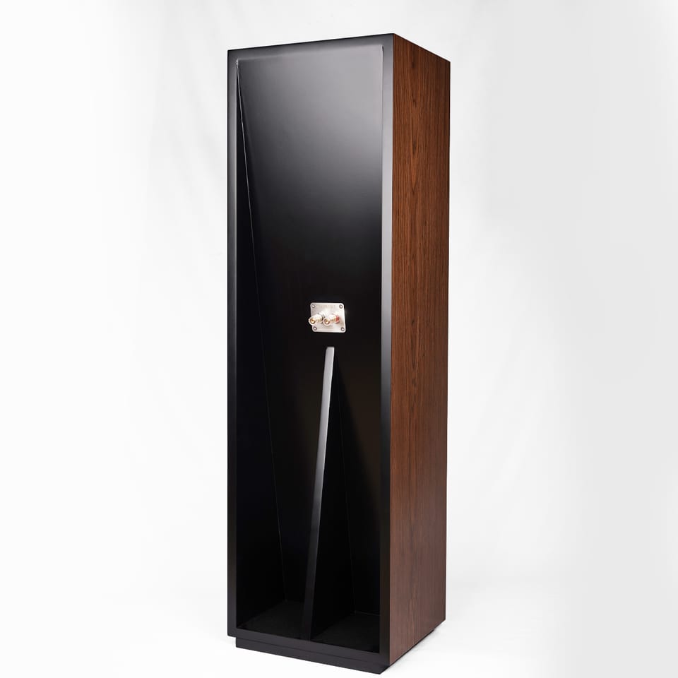 Kinnara floorstander from the rear three-quarter, showing a black rear panel with a single silver binding-post plate near the base and walnut veneer on the visible side.