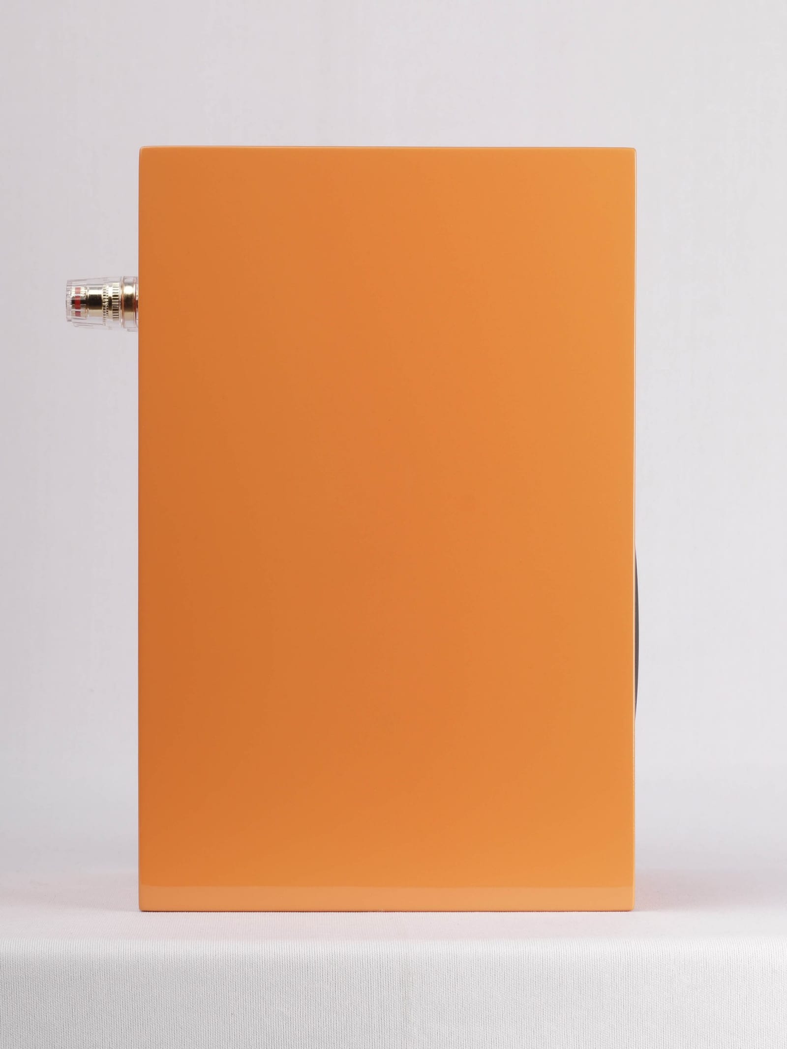 Micro-C in orange gloss seen in side profile, with the binding posts standing proud of the rear panel.