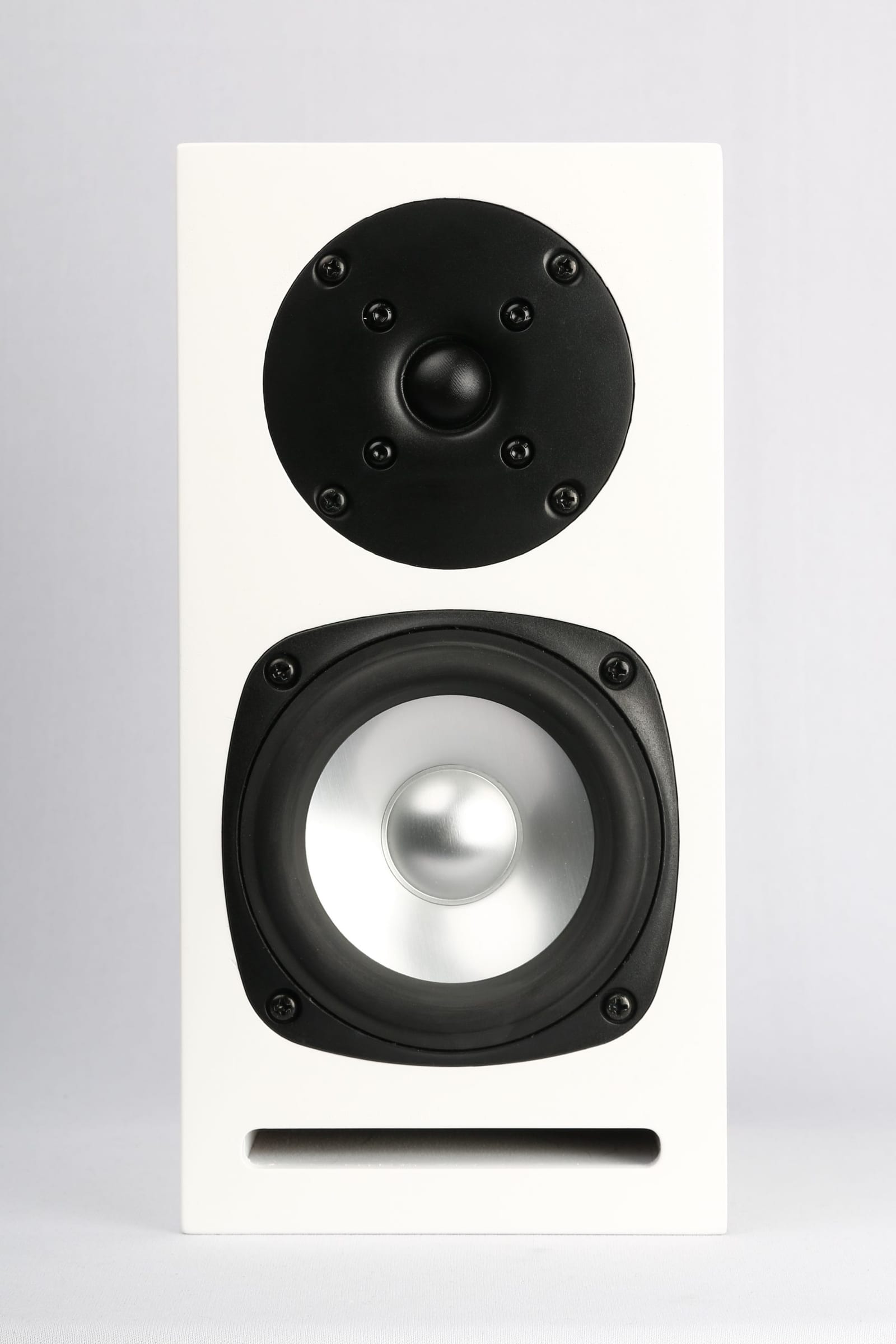 Micro bookshelf speaker in white, straight on: a black soft dome tweeter above a 4-inch aluminium cone midwoofer, with a slot port across the bottom of the baffle.
