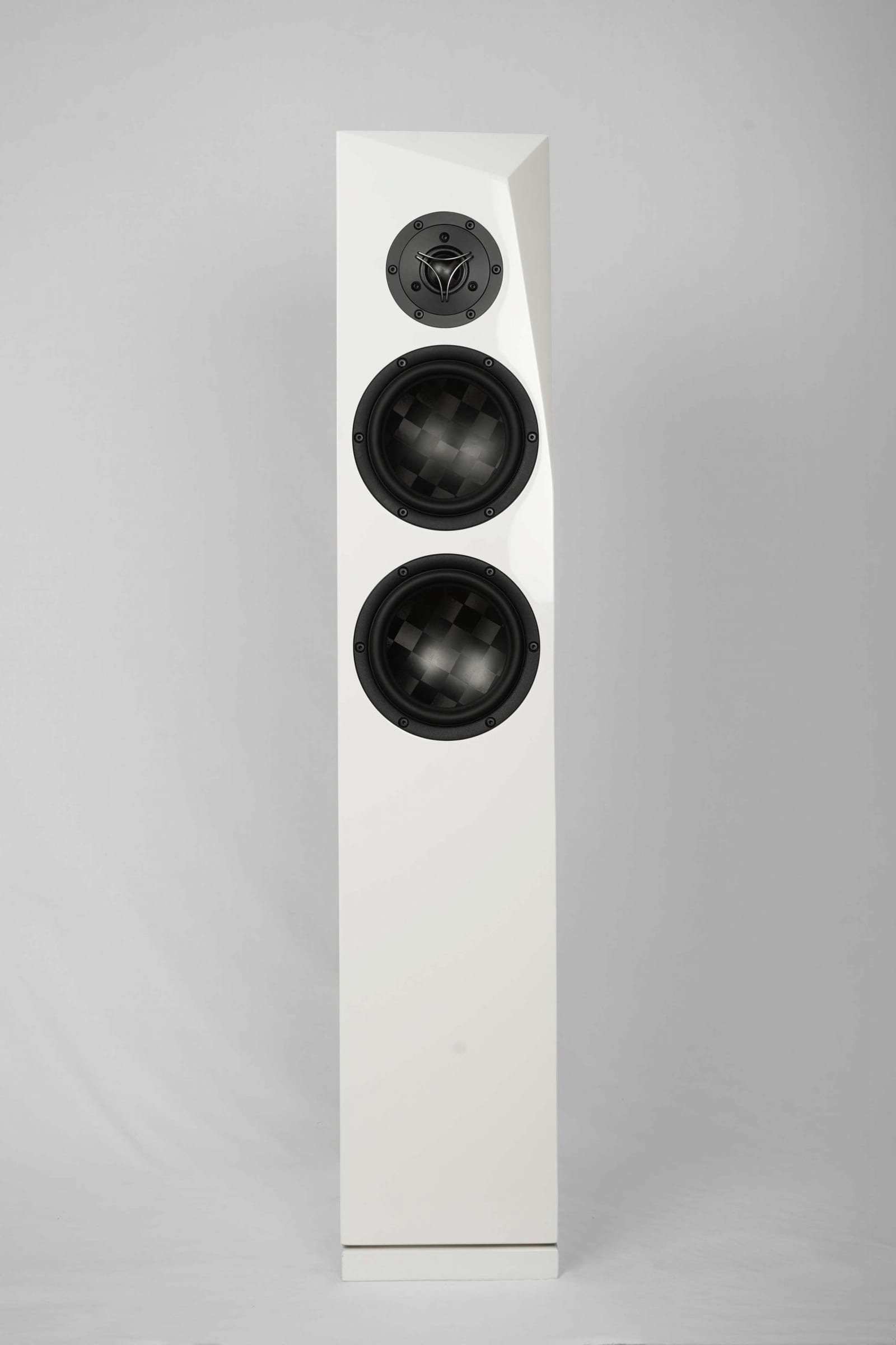 Rinjani TeXtreme floorstander in white gloss, straight on: a 29 mm TeXtreme dome tweeter on a black faceplate above two 6.5-inch midwoofers whose spread-tow carbon cones show a checkerboard weave, on a cabinet with a slanted front baffle.